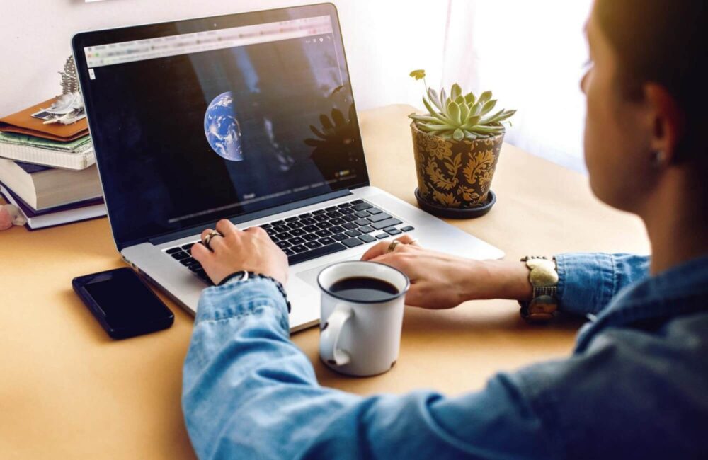 stylish-girl-with-coffee-on-background-of-laptop